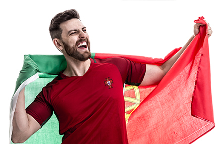 Jovem com camisola da seleção nacional com bandeira de Portugal às costas 